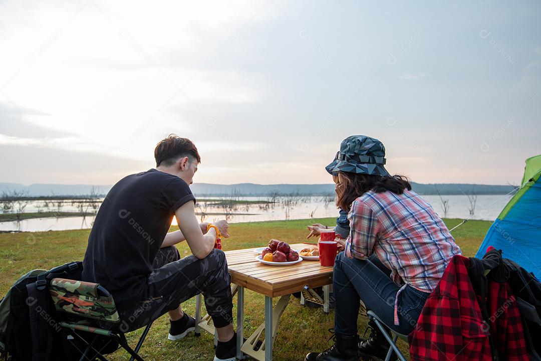 Um grupo de amigos asiáticos bebendo café e passando o tempo fazendo um piquenique nas férias de verão. Eles estão felizes e se divertem nos feriados.