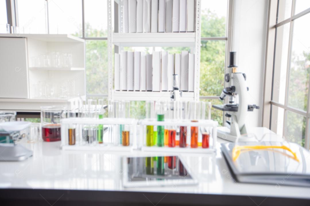 Microscope haze and a tablet and test tubes, micropipette and analysis results in a laboratory.