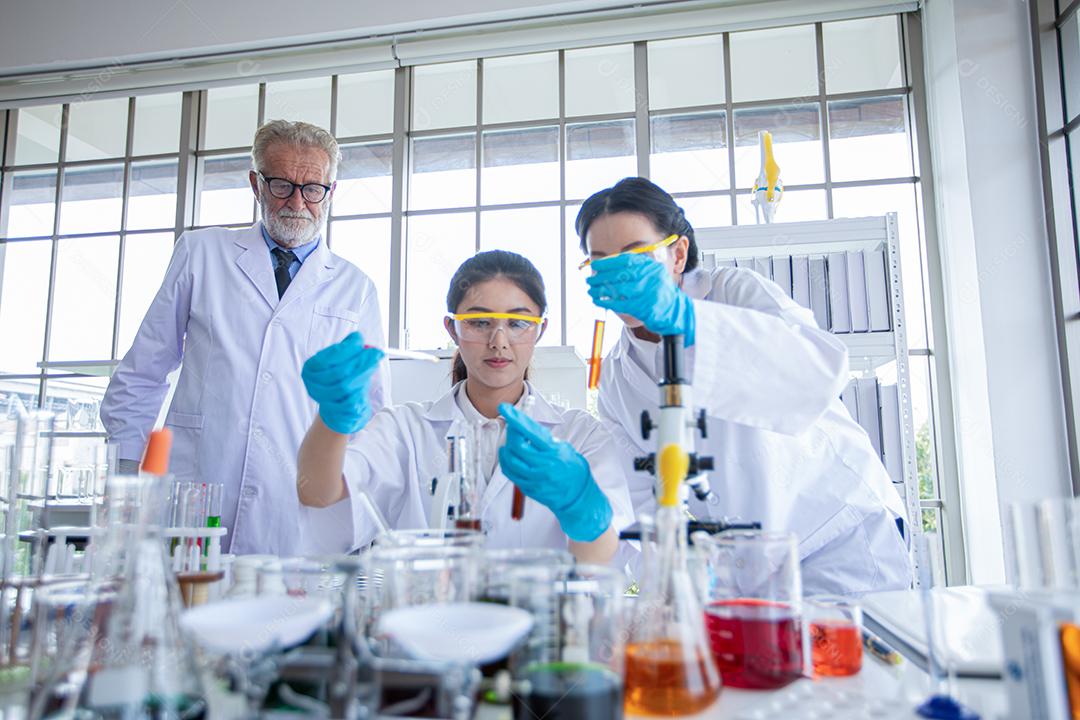 Pesquisa médica e cientistas estão trabalhando com um microscópio e um tablet e tubos de ensaio, micropipeta e resultados de análise em um laboratório.