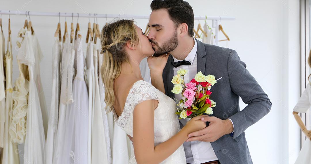 Os amantes dão flores para a noiva e se beijam felizes e o casal adora ficar no estúdio de casamento