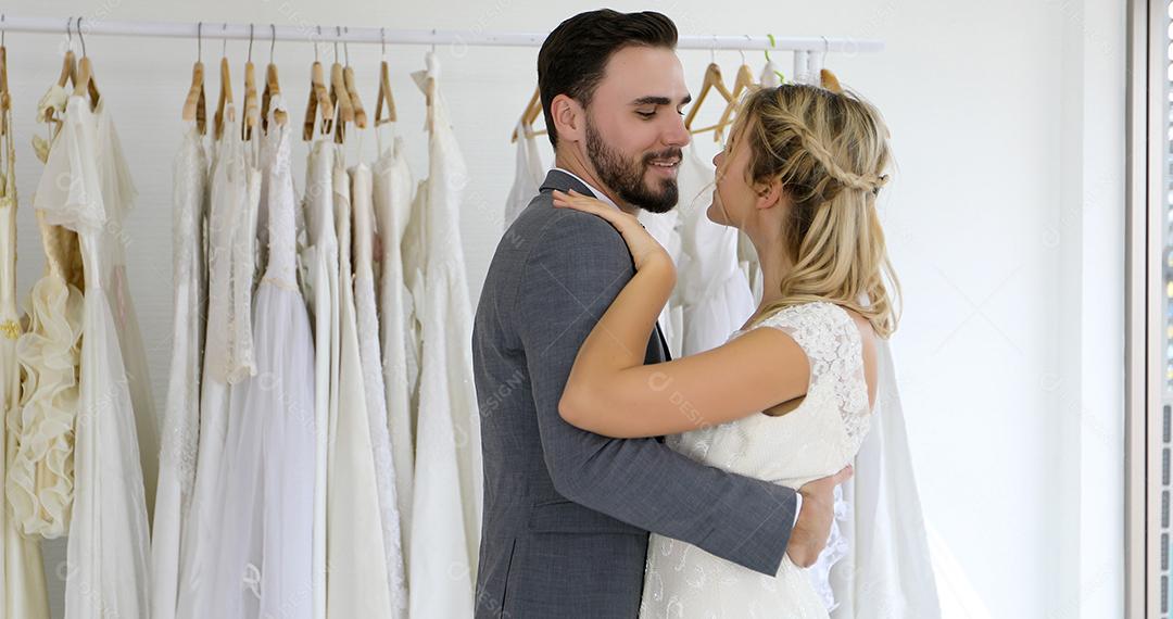 Os amantes dão flores para a noiva e se beijam felizes e o casal adora ficar no estúdio de casamento