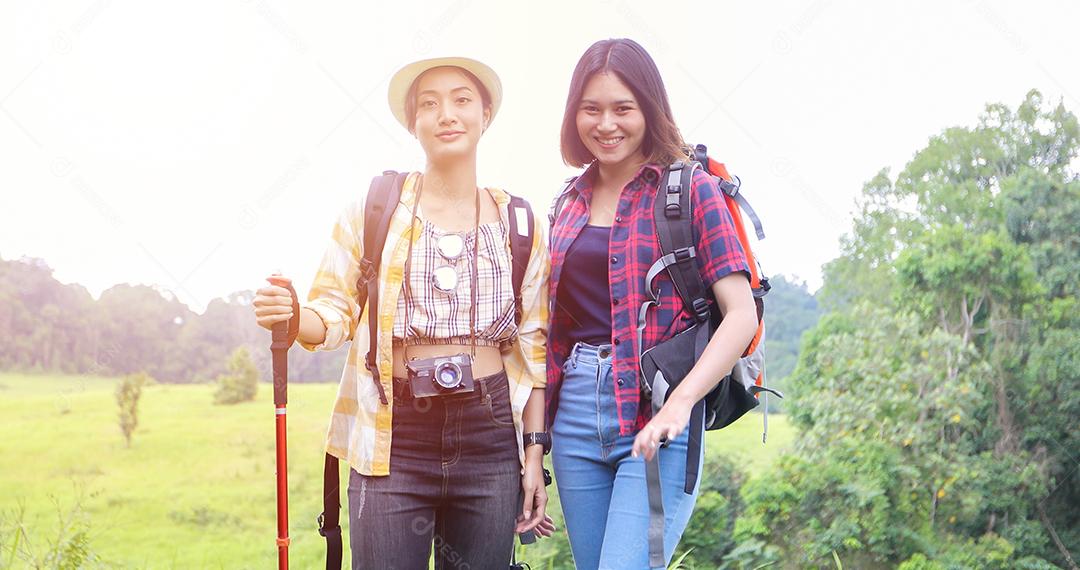 Grupo asiático de jovens Caminhando com mochilas de amigos caminhando juntos e olhando o mapa e tirando a câmera fotográfica pela estrada e parecendo feliz, Relaxe o tempo em viagens de conceito de férias