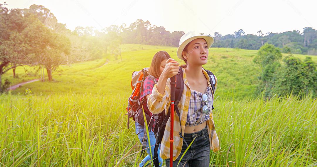 Grupo asiático de jovens Caminhando com mochilas de amigos caminhando juntos e olhando o mapa e tirando a câmera fotográfica pela estrada e parecendo feliz, Relaxe o tempo em viagens de conceito de férias