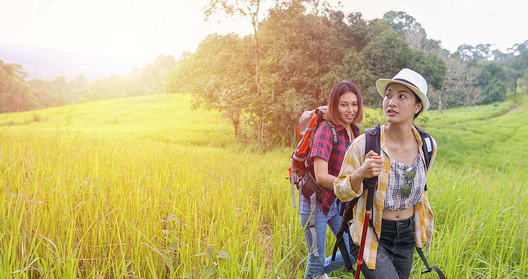 Grupo asiático de jovens Caminhando com mochilas de amigos caminhando juntos e olhando o mapa e tirando a câmera fotográfica pela estrada e parecendo feliz, Relaxe o tempo em viagens de conceito de férias