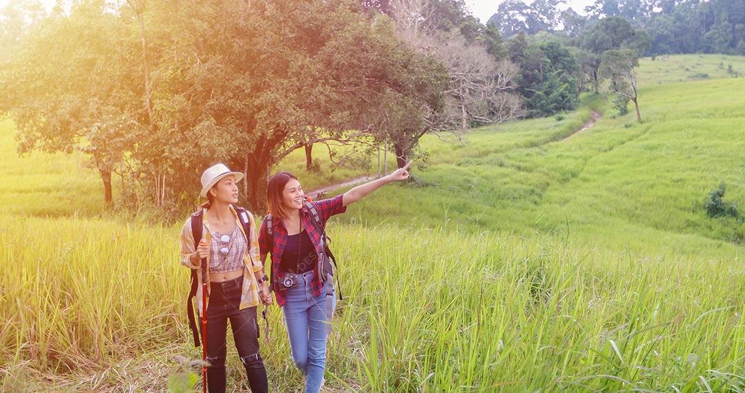 Grupo asiático de jovens Caminhando com mochilas de amigos caminhando juntos e olhando o mapa e tirando a câmera fotográfica pela estrada e parecendo feliz, Relaxe o tempo em viagens de conceito de férias