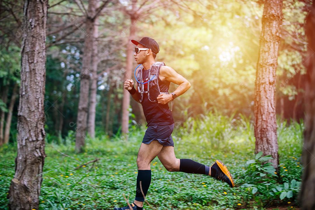 Um homem Runner of Trail e pés de atleta usando sapatos cpara trilha na floresta