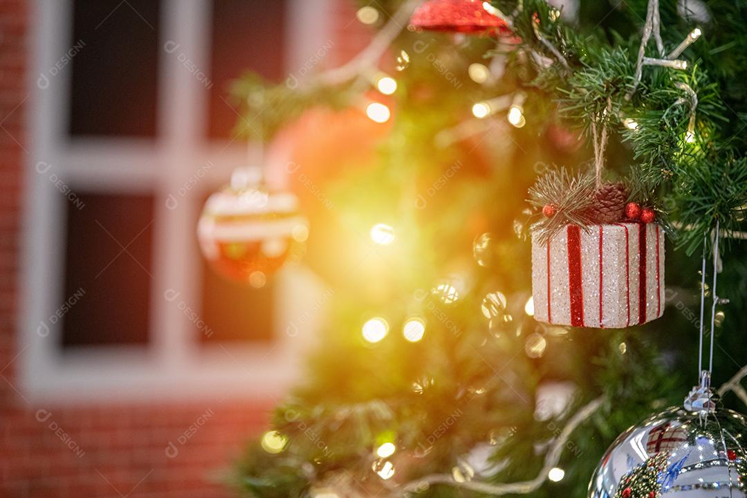 Feliz ano novo e ornamentos na árvore de Natal com caixa de presente, foco turva e suave