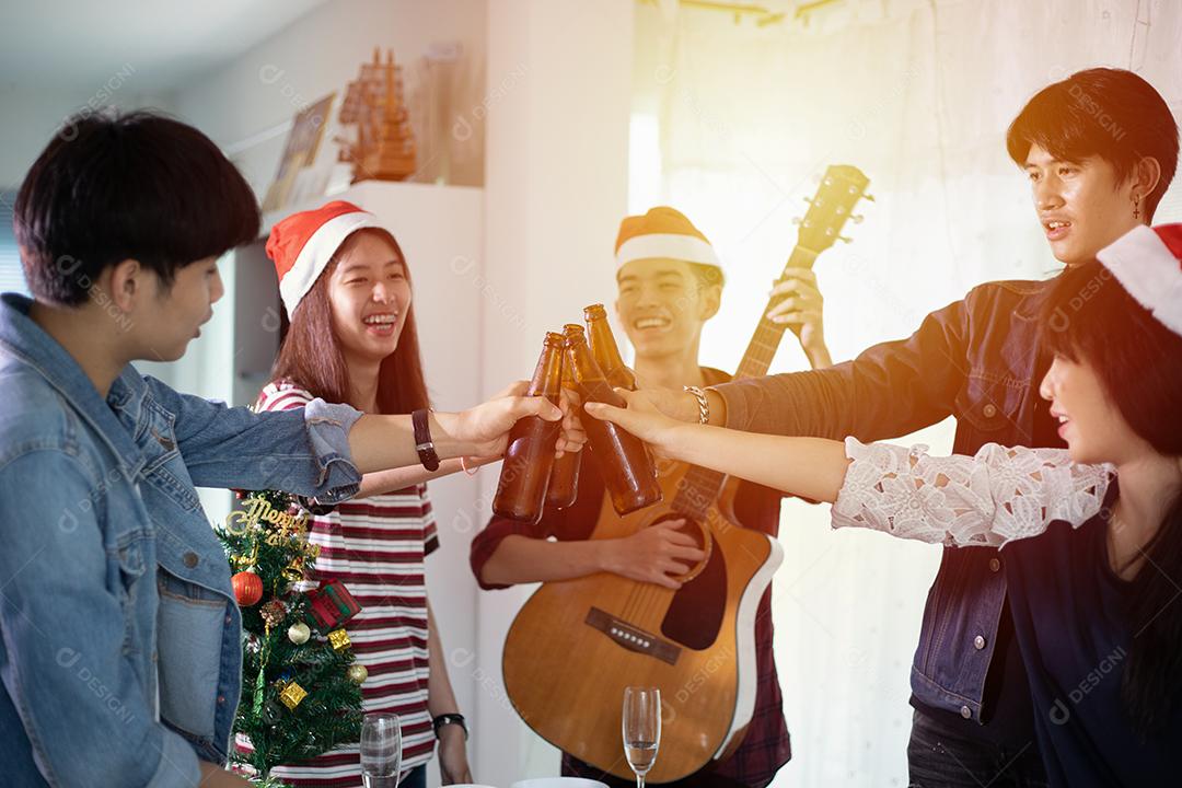 Grupo asiático de amigos festejando com bebidas alcoólicas de cerveja e jovens desfrutando em um bar brindando coquetéis