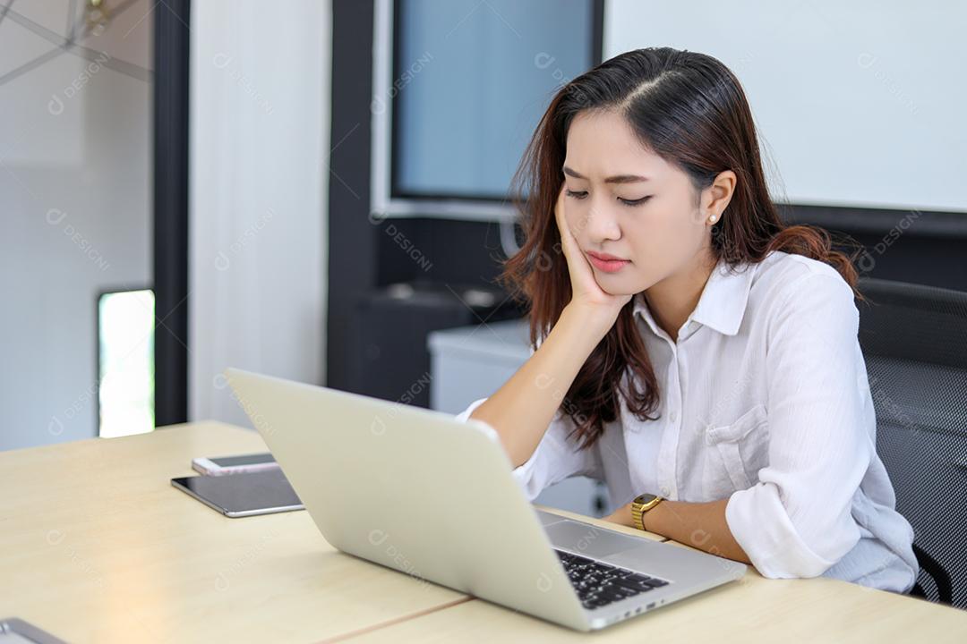 Mulheres de negócios asiáticos usando notebook e sério e dor de cabeça para trabalhar