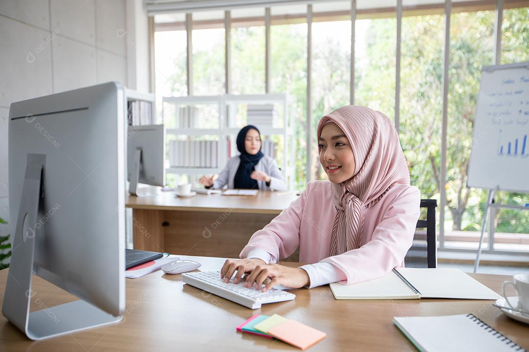 Mulher de negócios muçulmana em roupas tradicionais trabalhando e discutindo na reunião no escritório