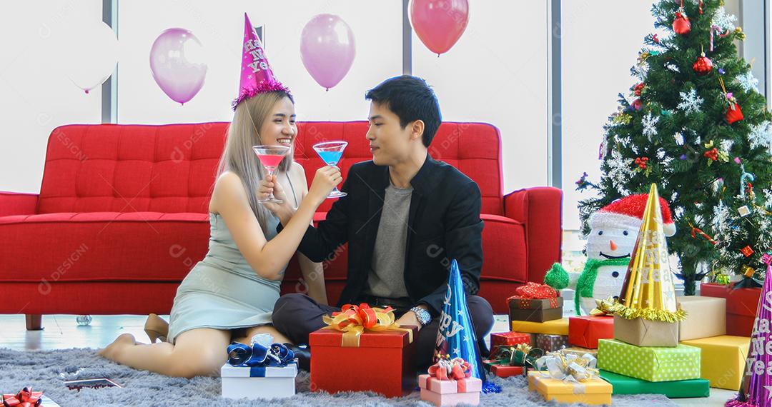 Amante de casal asiático segurando números de 2020 comemorando um ano novo em um bar gritando e rindo e contando até a meia-noite em uma festa de ano novo