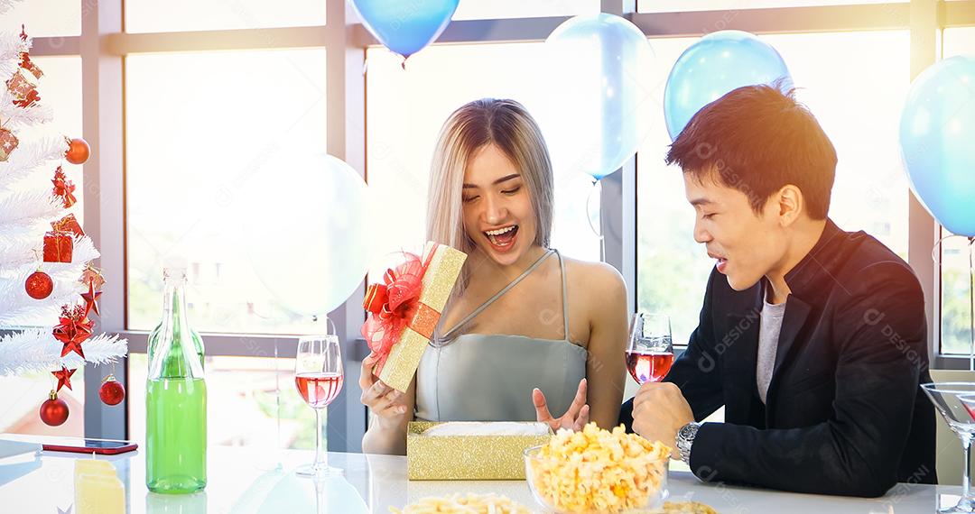 Amante de casal asiático está dando uma caixa de presente com presente de Natal no feriado de Natal e feliz ano novo empada