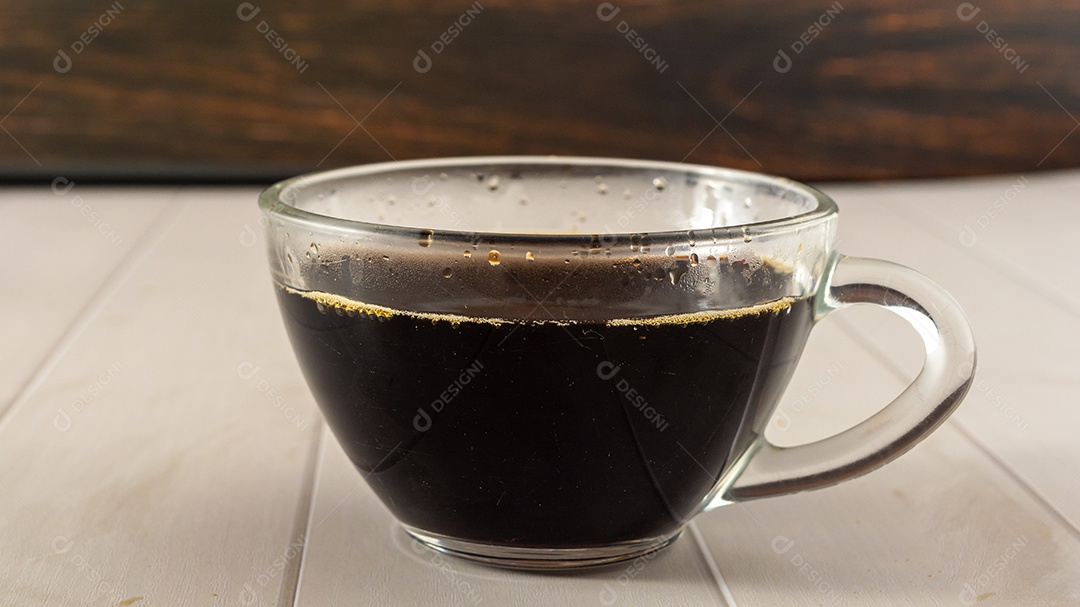 café preto no copo de vidro transparente com elementos no fundo