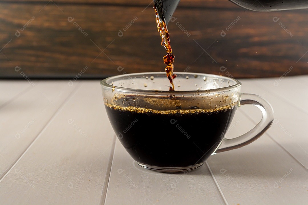café preto no copo de vidro transparente com elementos no fundo