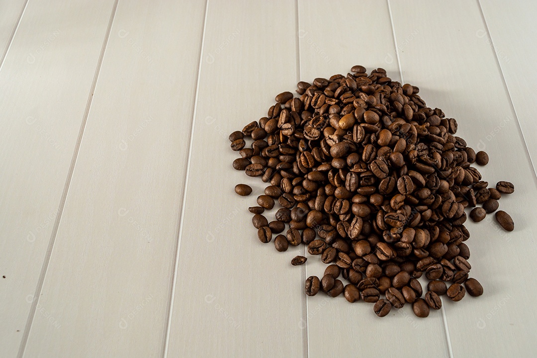 pilha de grãos de café sobre a mesa de fundo branco