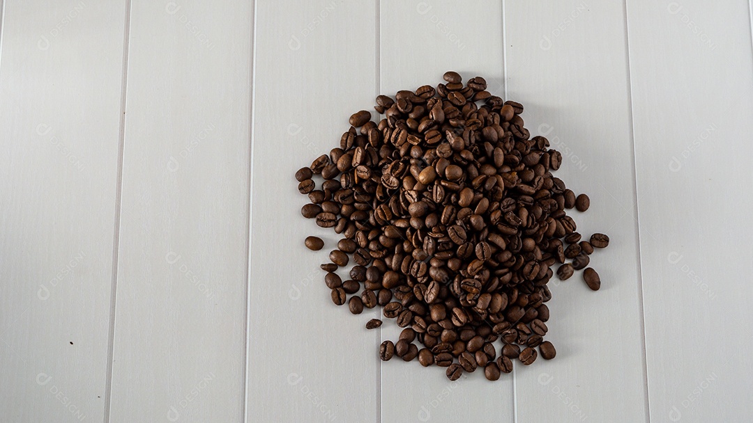 pilha de grãos de café sobre a mesa de fundo branco