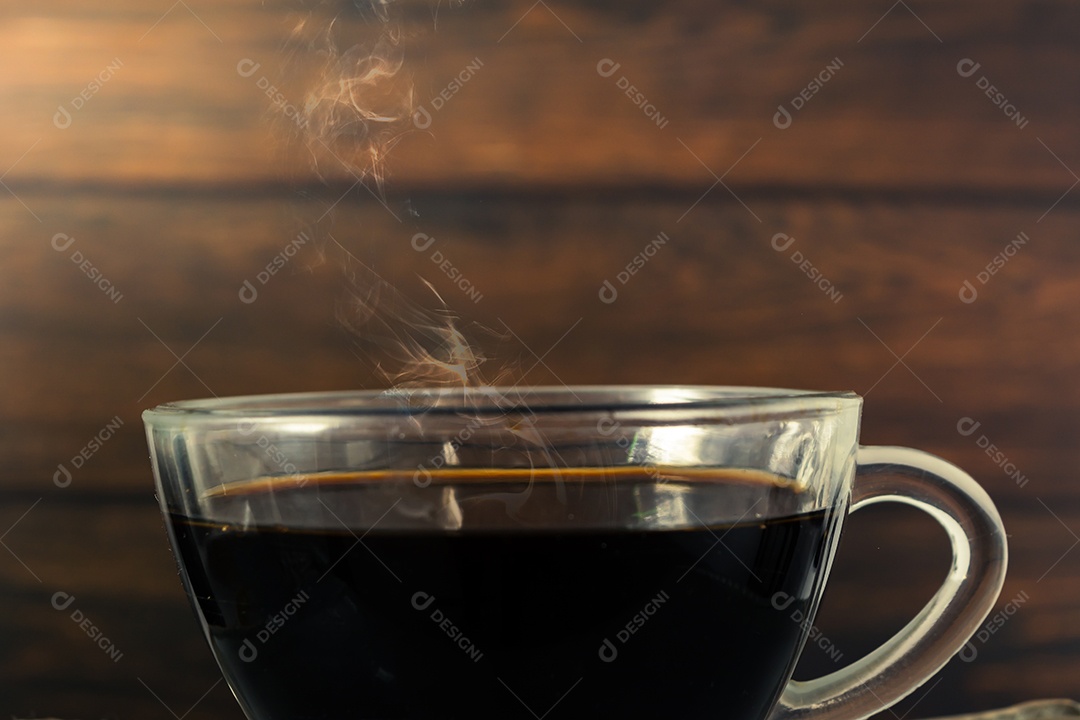 copo de vidro com café preto e fumaça quente em fundo de madeira
