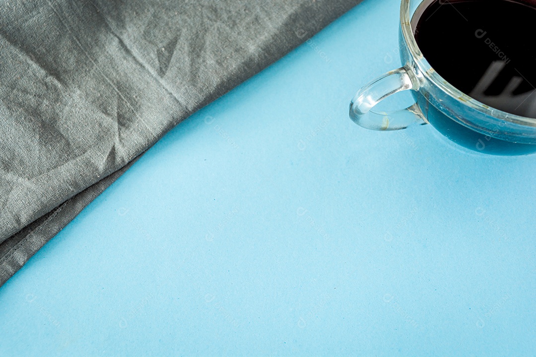 café preto e pano cinza sobre pano de fundo azul