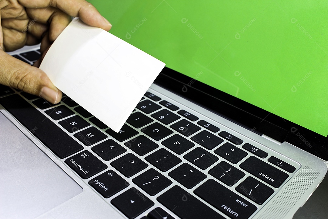 Mãos usando laptop e verificando cartões de visita para ligar para compras on-line