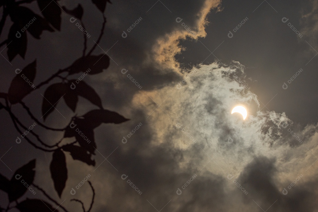 Eclipse solar com nuvens no céu