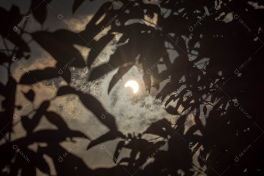 Eclipse solar com nuvens no céu