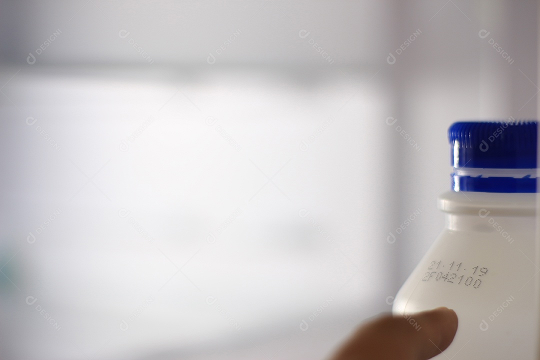 Mãos de pessoa pegando objeto sobre geladeira