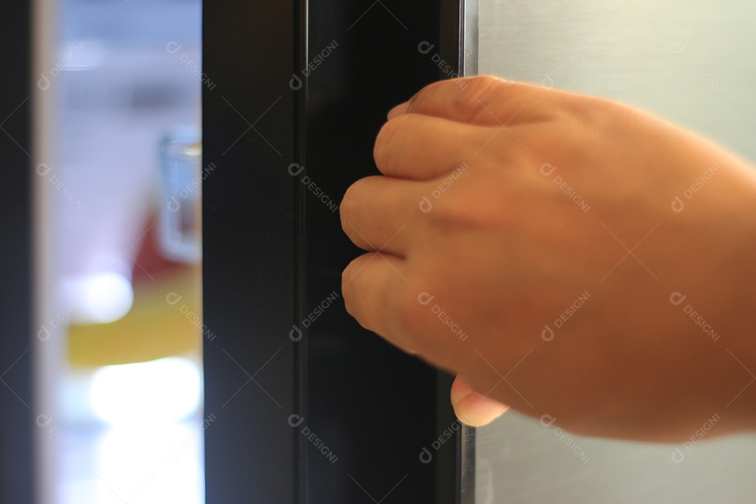 Mãos de pessoa abrindo geladeira