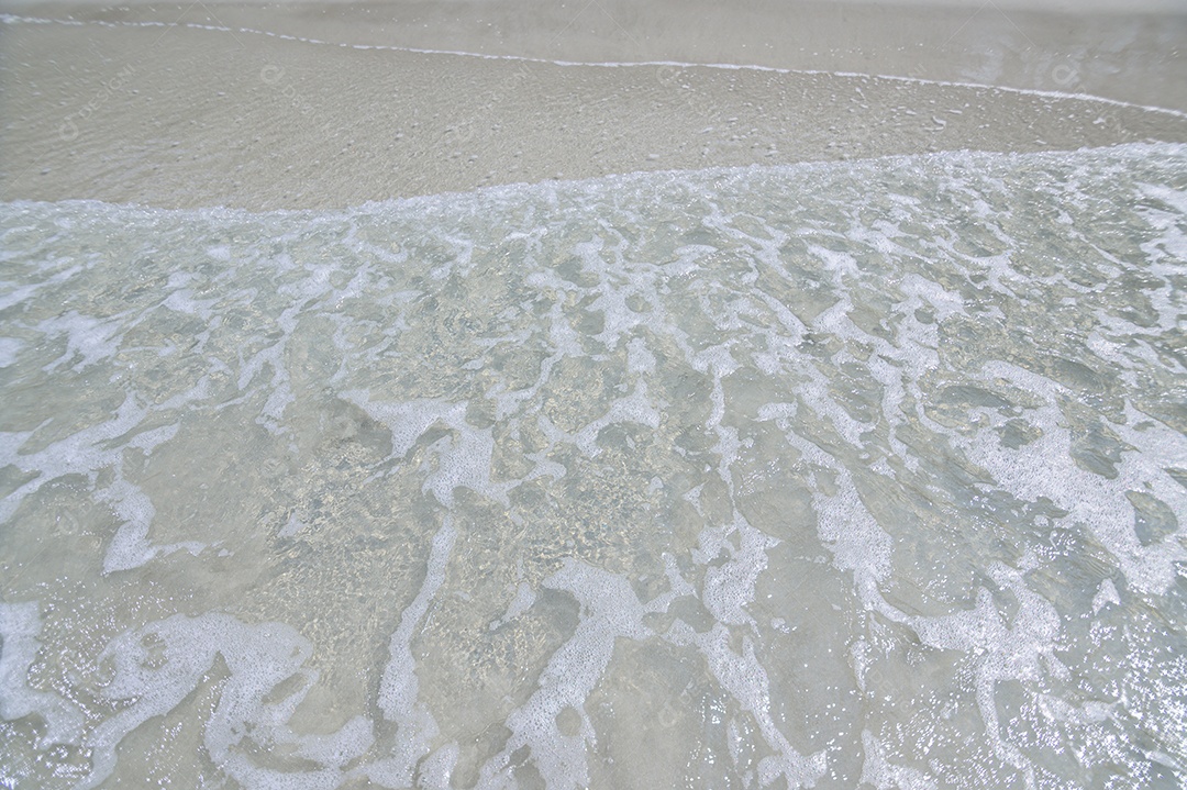 Ondas de água e areia à beira-mar