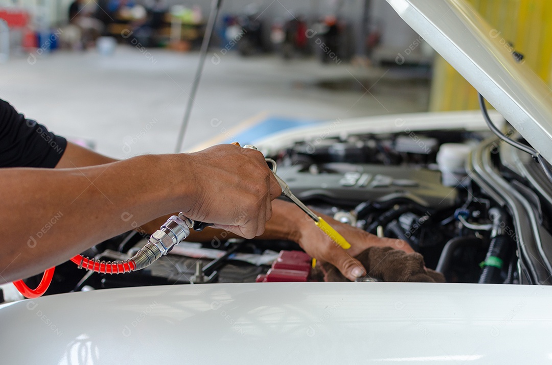 As mãos de um homem, verificando a máquina do automóvel.