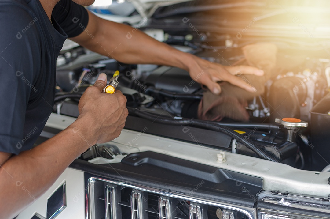 As mãos de um homem, verificando a máquina do automóvel.