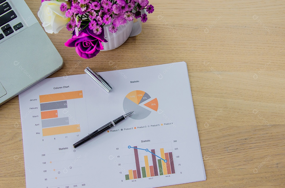 Laptop com gráficos, tabelas, diagramas em cima da mesa.