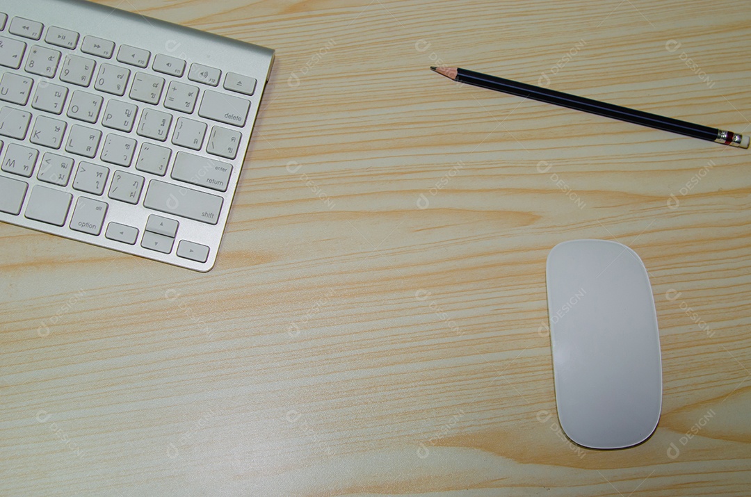 Mesa de escritório teclado, mouse e lápis sobre fundo de madeira.