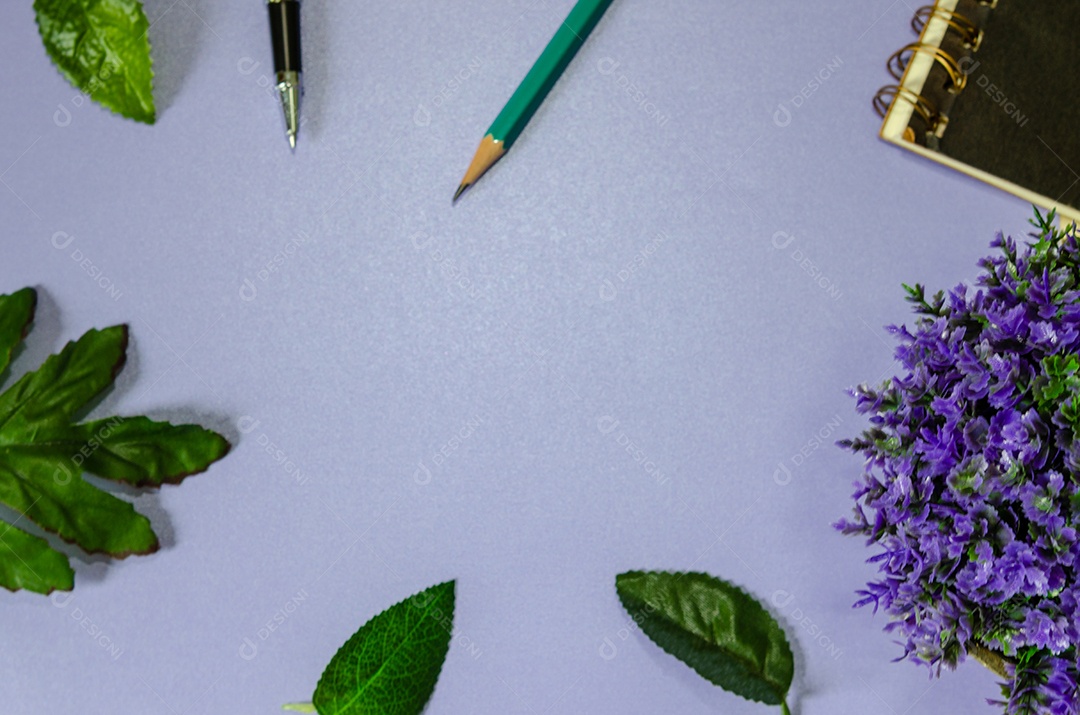 Folhas verdes e caneta e livro sobre um fundo roxo. espaço de cópia de tom vintage.
