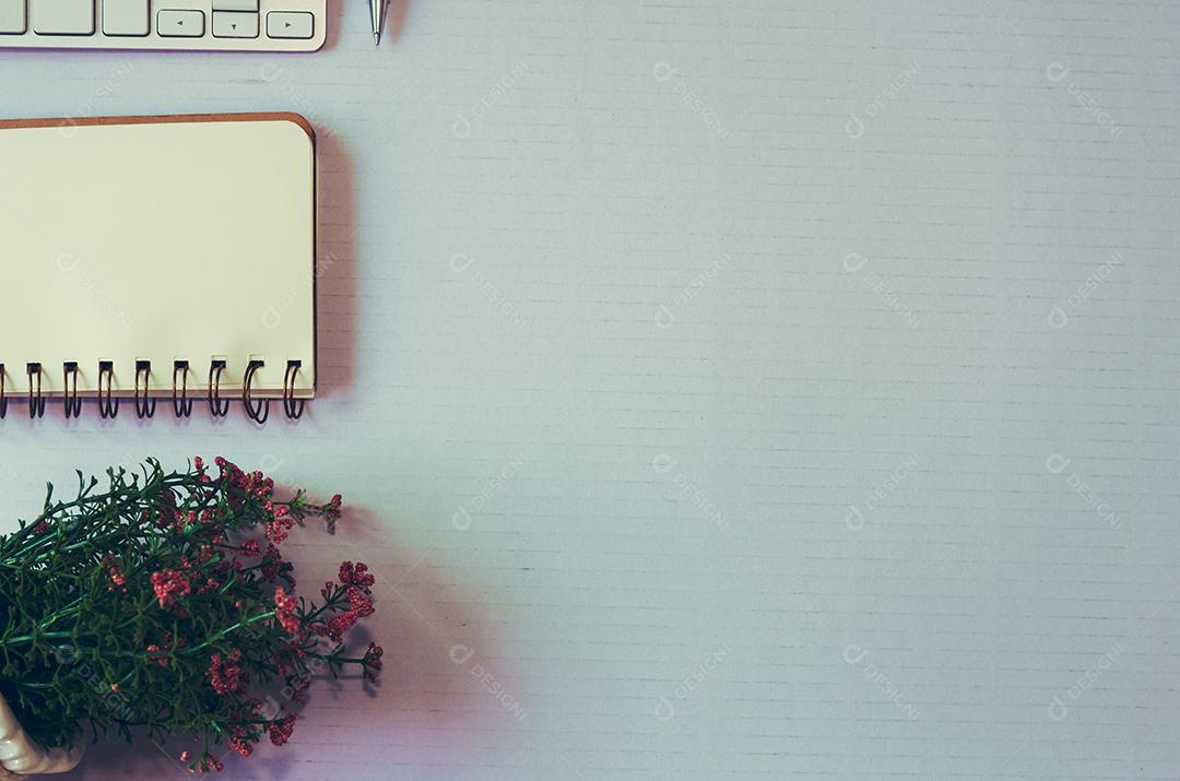 Notebook de teclado de vista superior e livro e caneta no fundo branco espaço de cópia