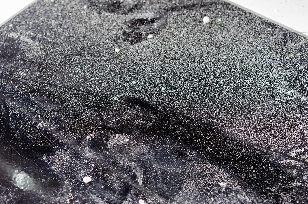 Pó de pó branco no chão de ladrilho preto.