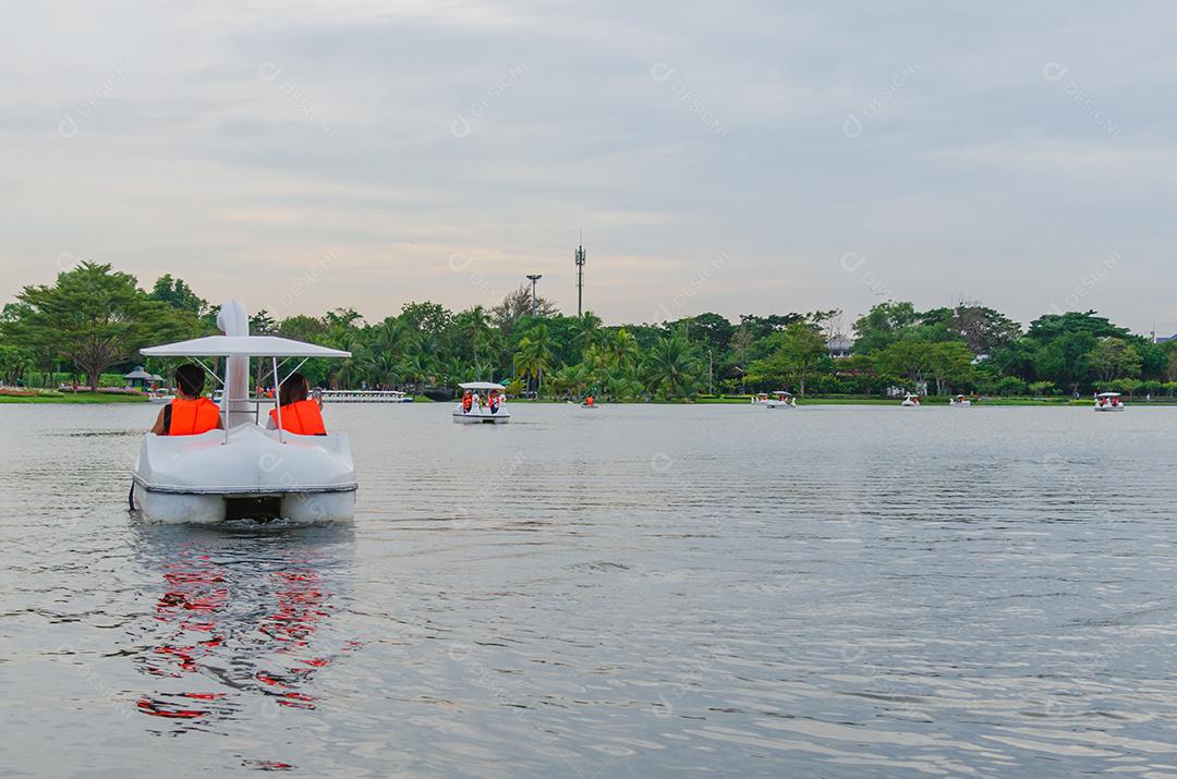 Duas mulheres montando um barco de cisne em uma lagoa do parque.