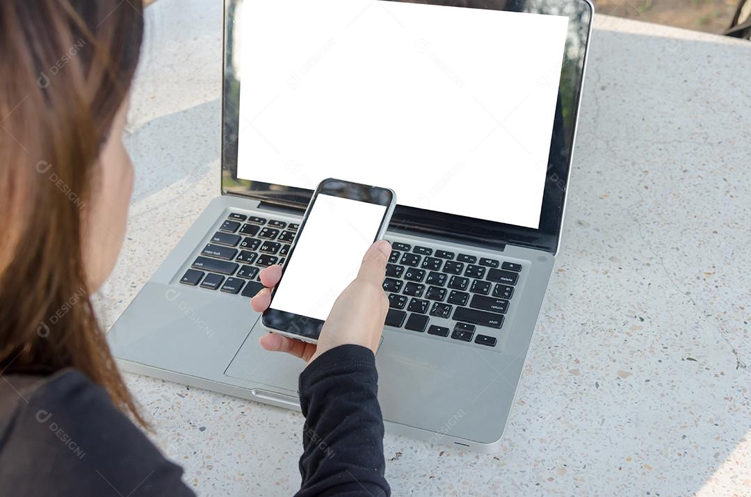 Mulher bonita asiática usando telefone inteligente para negócios e computador portátil.