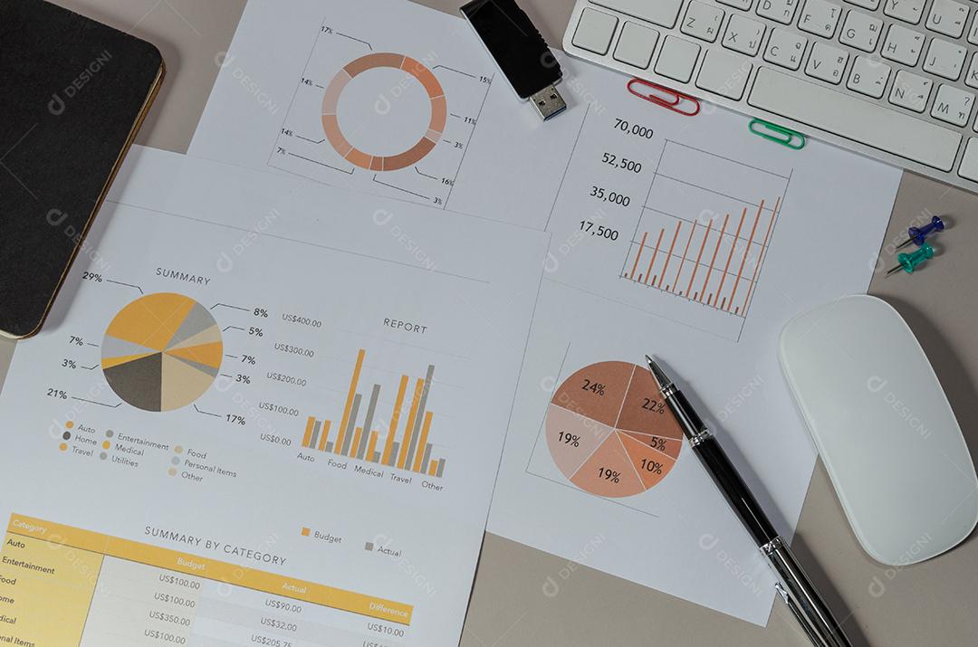 gráficos e gráfico com computador e mouse na mesa.
