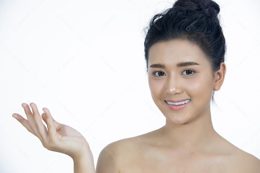 Uma linda mulher asiática usando um produto de cuidados com a pele, hidratante ou loção cuidando de sua pele seca. Creme hidratante nas mãos femininas.