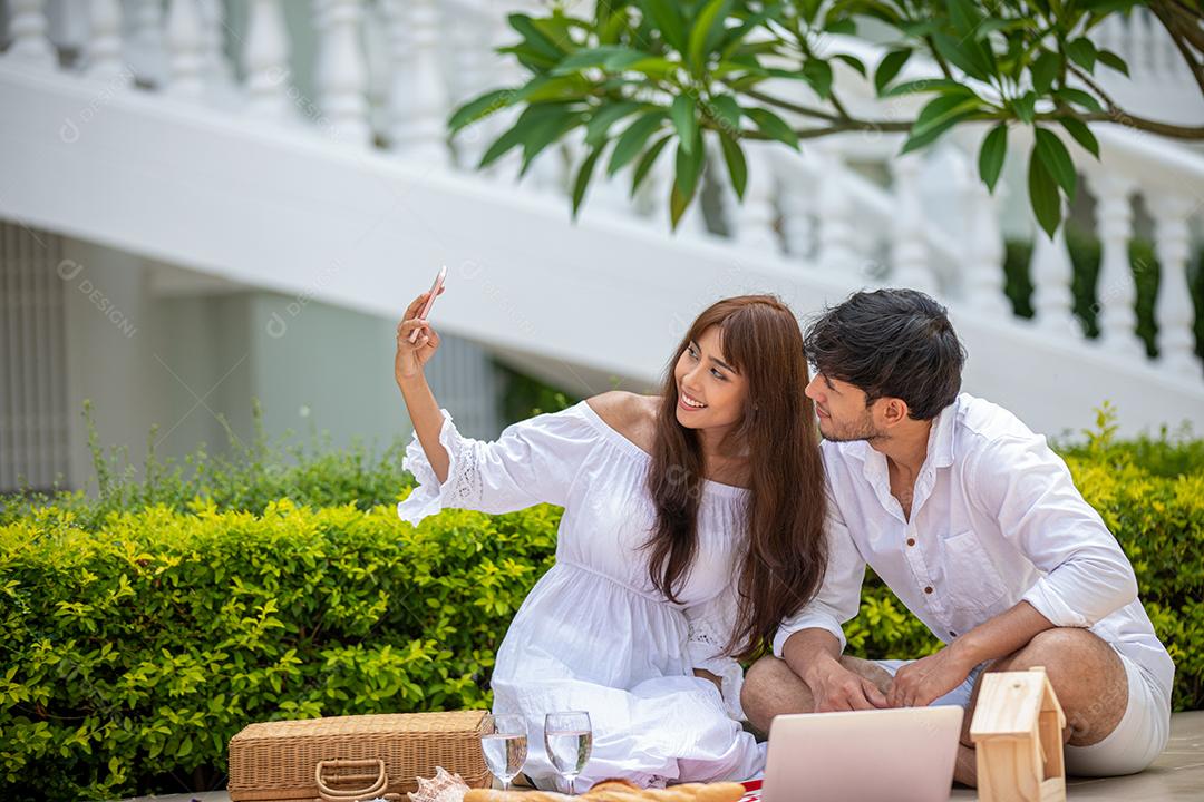 Feliz amante de casais românticos conversando e bebendo vinho enquanto faz um piquenique