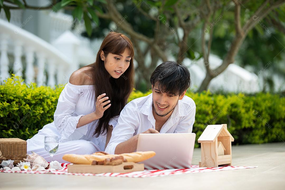 Feliz amante de casais românticos conversando e bebendo vinho enquanto faz um piquenique