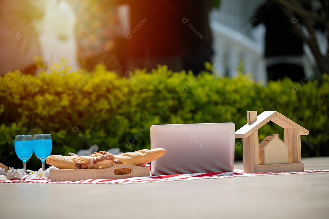 Cesta de piquenique com comida e bebida no cobertor. Almoço de piquenique ao ar livre em um campo em dia ensolarado com pão