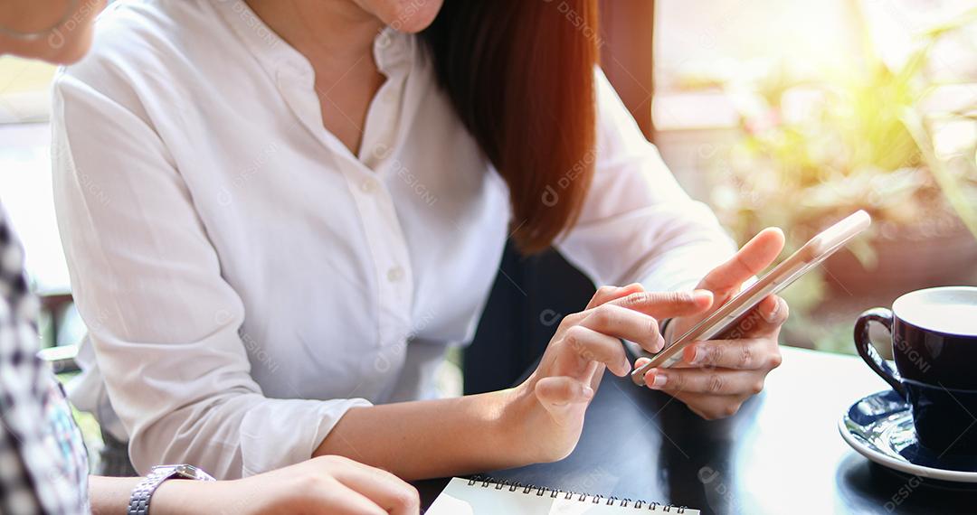 Duas mulheres asiáticas bebendo café em um café e fazendo compras online em telefones inteligentes