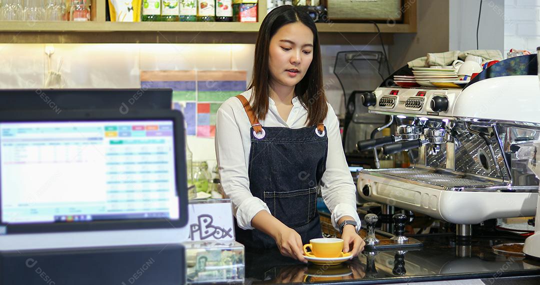 Barista atendendo cliente e mulher está pagando café com cartão de crédito na cafeteria