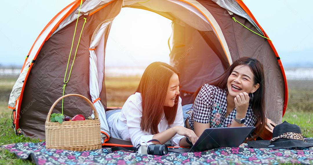 Um grupo de amigos asiáticos jogando Ukelele e passando o tempo fazendo um piquenique nas férias de verão. Eles estão felizes e se divertem nos feriados.