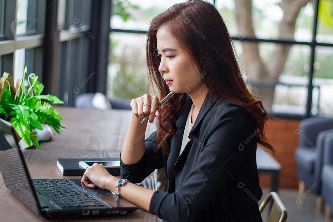 A empresária asiática está pensando em criar novos empregos e está sorrindo e trabalhando feliz