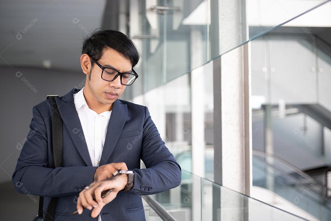 Empresários asiáticos usando máscara e usando seus telefones e vão trabalhar de manhã.