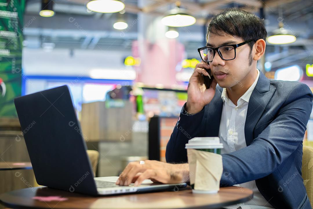 Empresários asiáticos usando máscara e usando seus telefones e vão trabalhar de manhã.