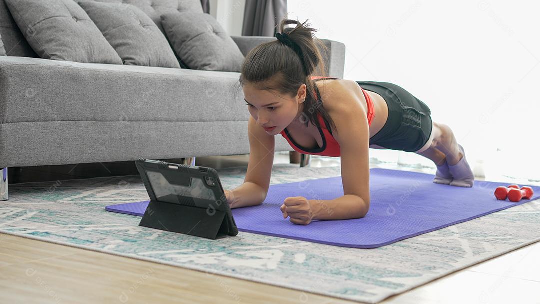 Mulher jovem fitness muscular fazendo exercícios de alpinista em casa no chão da sala de estar