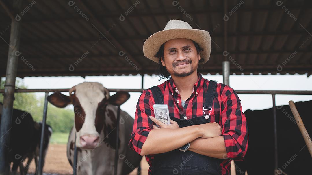 agricultores sorridentes e felizes obtêm renda da fazenda de gado leiteiro. Conceito de indústria agrícola, agricultura e pecuária, vaca na fazenda de gado leiteiro comendo feno. Estábulo.